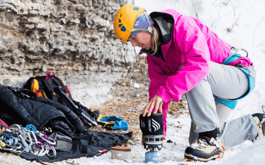 Outdoor enthusiast using Jetboil Zip camping stove on snowy terrain. Jetboil Zip Review - The Trailhead Blog - Adventure Travel Gear.